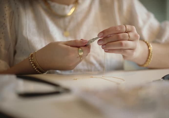 A woman that is working on jewelry