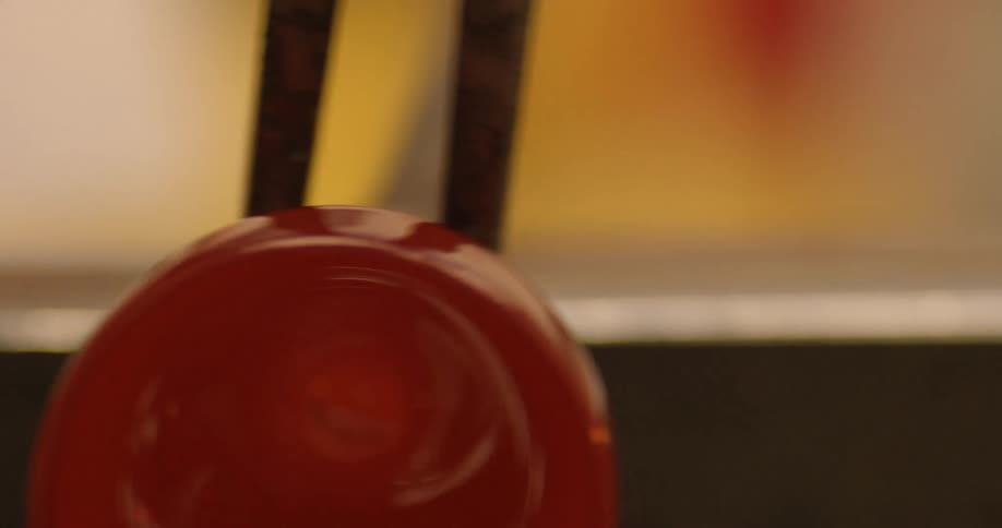 A tong is being used to roll glass