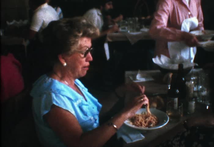 Woman eating a dish of pasta in a restaurant