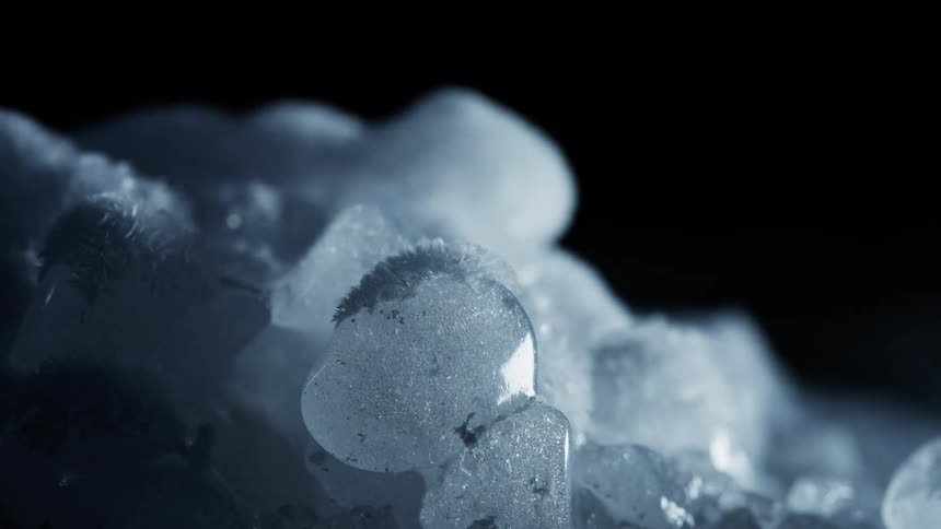 A time lapse shows dry ice evaporating and ice crystals forming on its exterior surface