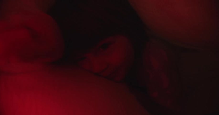 A boy underneath the covers with a flashlight