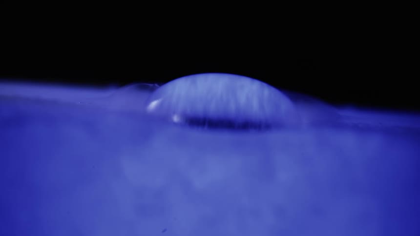 Purple white and black colors that look like a water drop surrounded by purple smoke