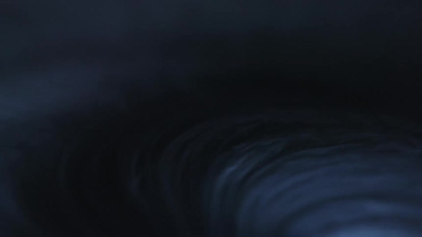 A white nugget swirls and smokes against black