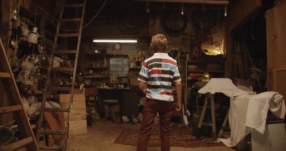 A child carries a fishbowl into the shed