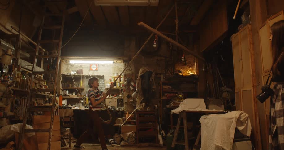 A boy is pulling a rope to lift a light up