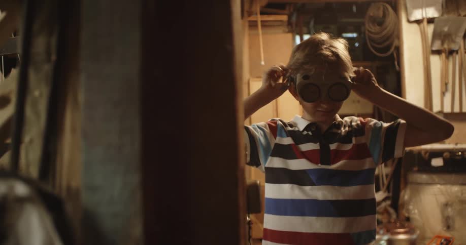 A boy puts on a large pair of goggles