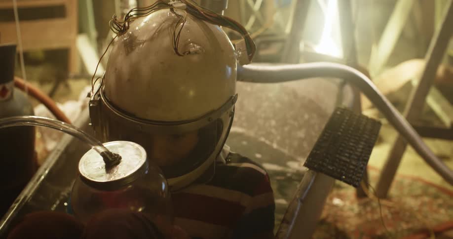 Young boy playing in the basement wearing a helmet inside a bath tub
