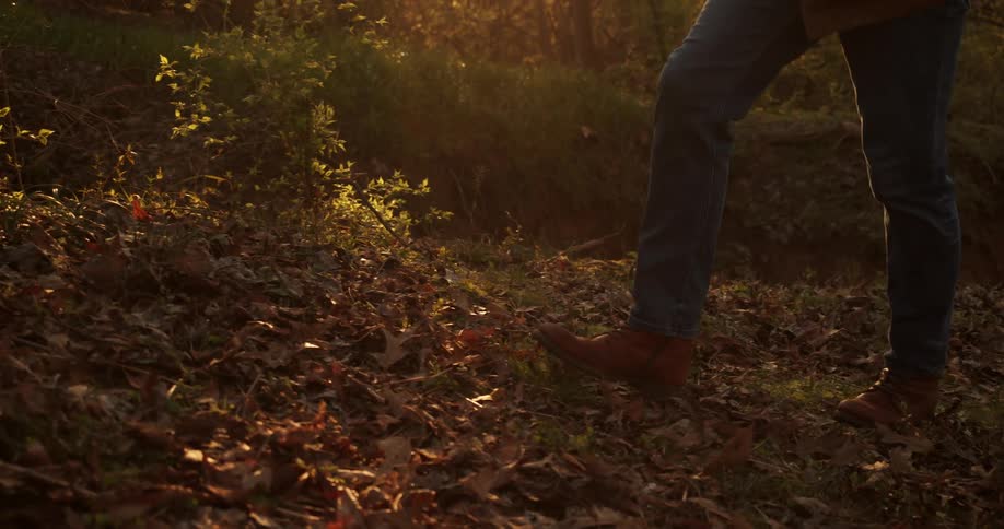 A man that is walking around outdoors in a forest
