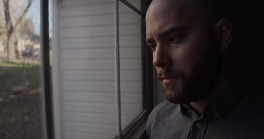 A man on a porch with a house in the background