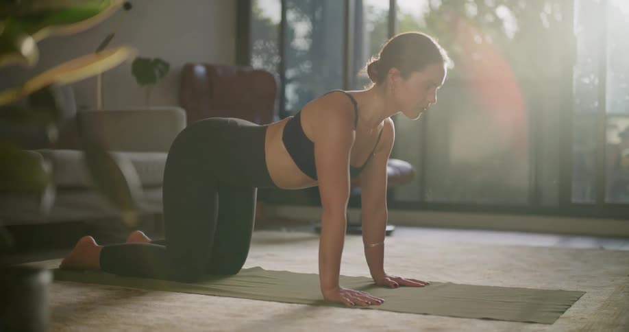 A woman is doing yoga in her living room