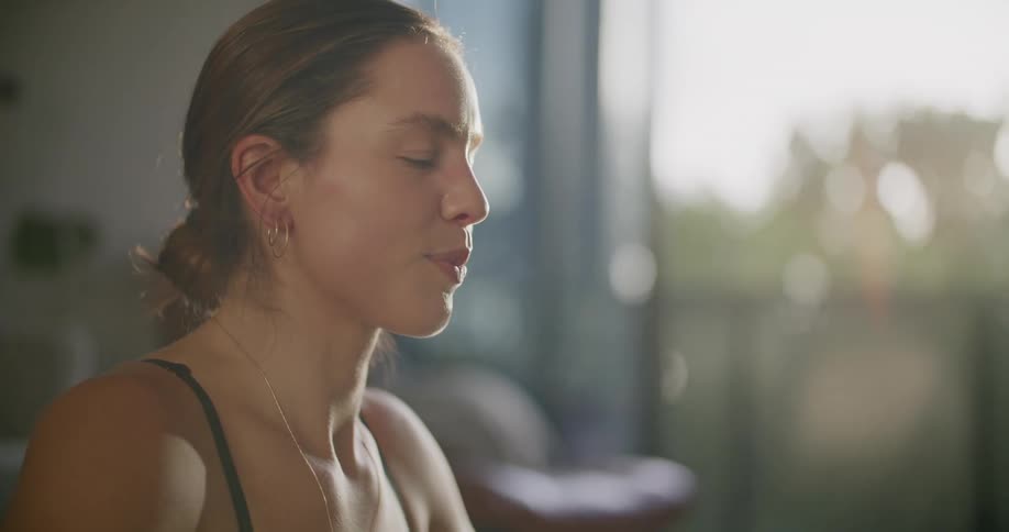 Young woman sitting on the living room relaxes after workout