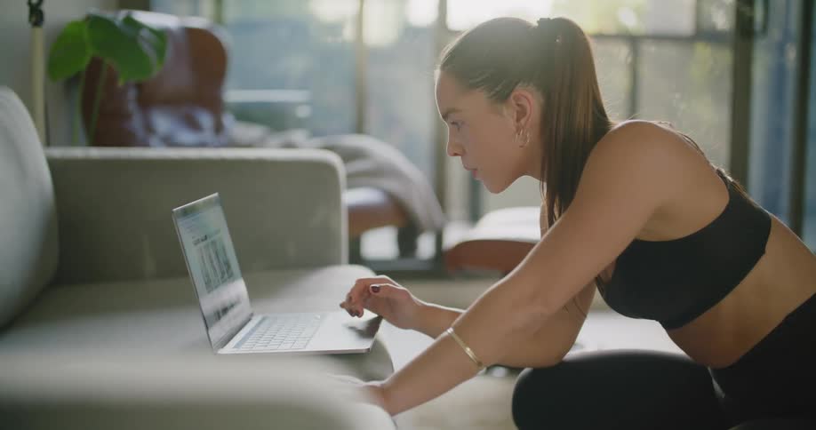 A woman searching for something on a laptop in her lounge room
