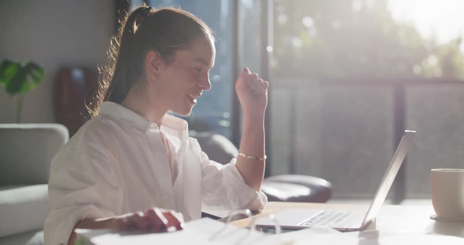 Woman smiles during video call sitting at coffee table in living room
