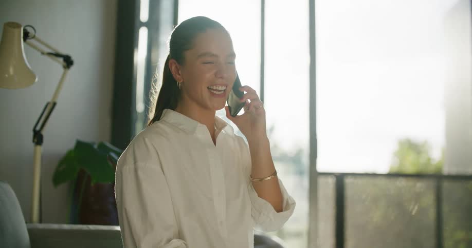 A woman is talking on the phone at home