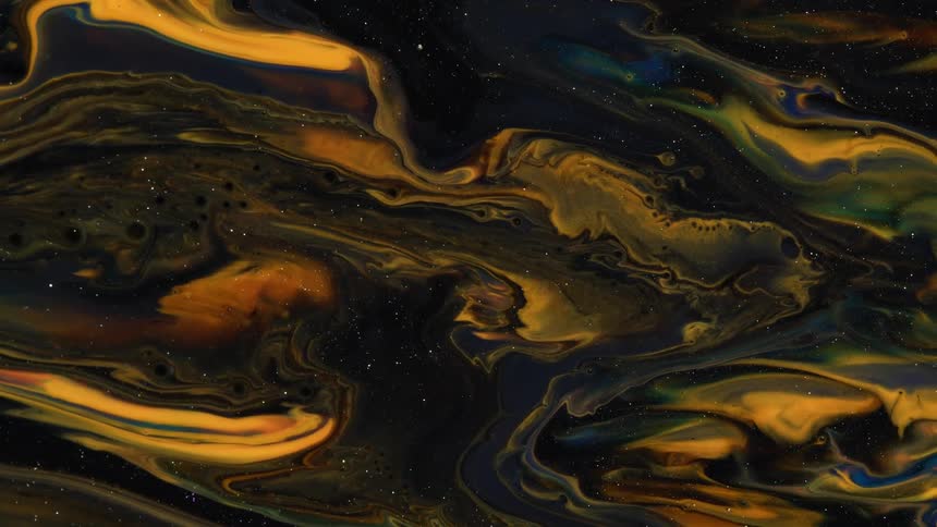 Swirls of brown and black sparkling liquid ink forms psychedelic abstract paterns