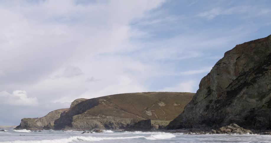 A rocky coast with waves with the sky and clouds in the background