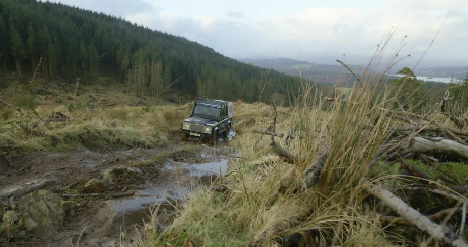 The vehicle is driving in the mud up the hill