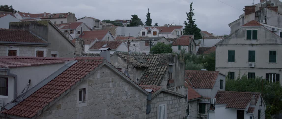A row of houses sit under a cloudy sky