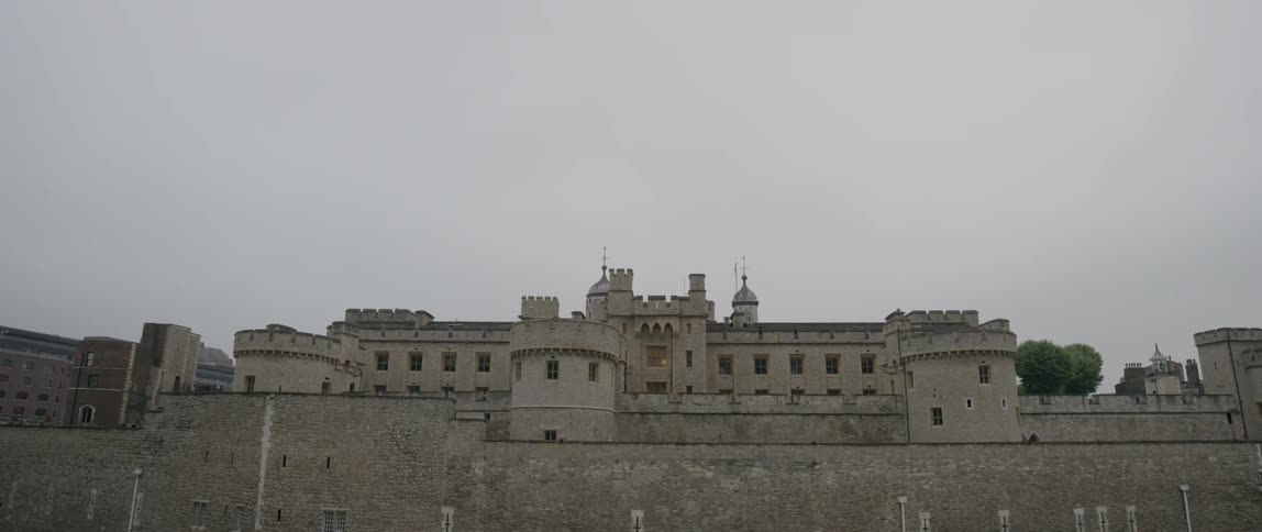 A building is behind a stone wall