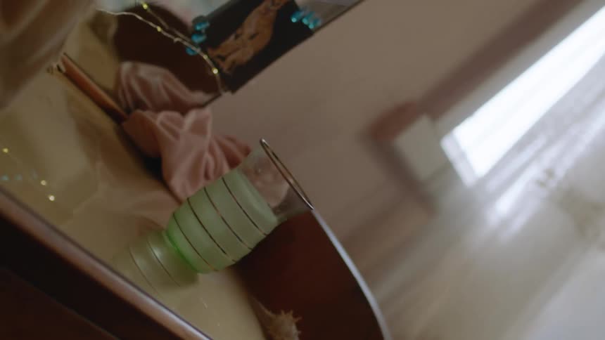 A glass filled with green liquid shakes over a counter at home