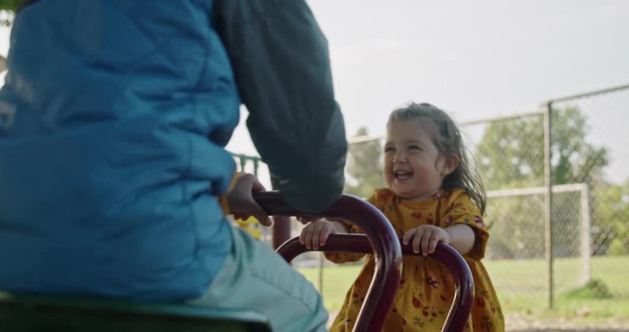 Kids play on seesaw in playground