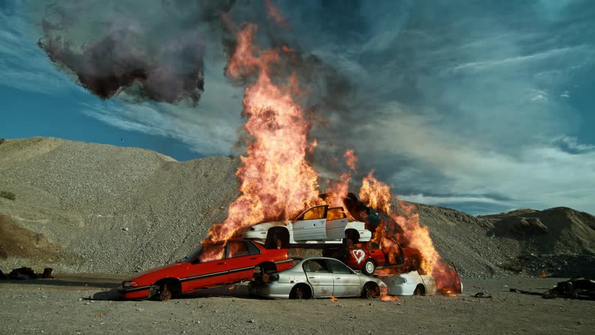 A stack of vehicles explode into flames
