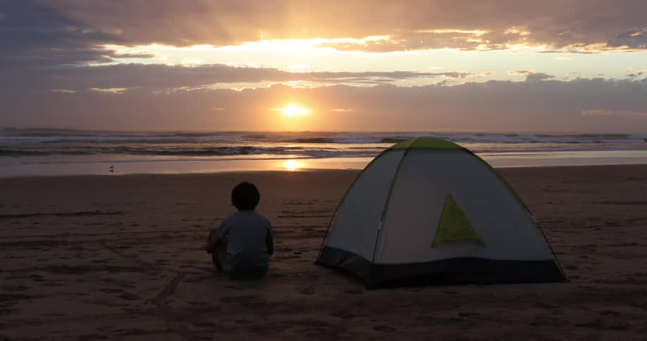 A person is camping on the beach with a tent