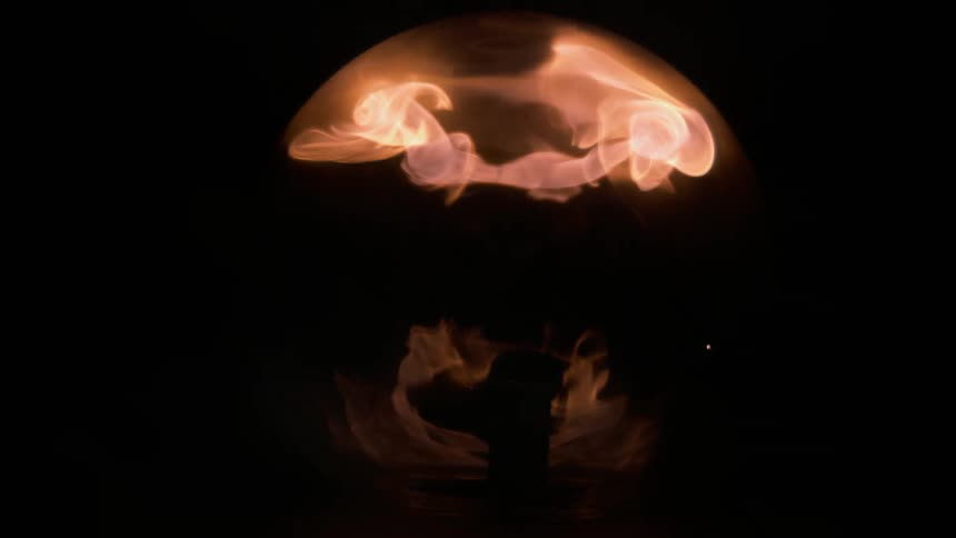 Large flames rise up inside a sphere shape from a brick shaped device