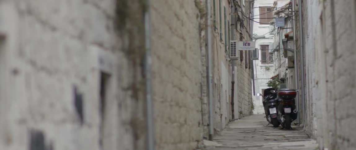 Two scooters parked in a narrow alley