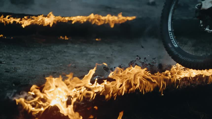 Bike goes over the top of flaming burning logs
