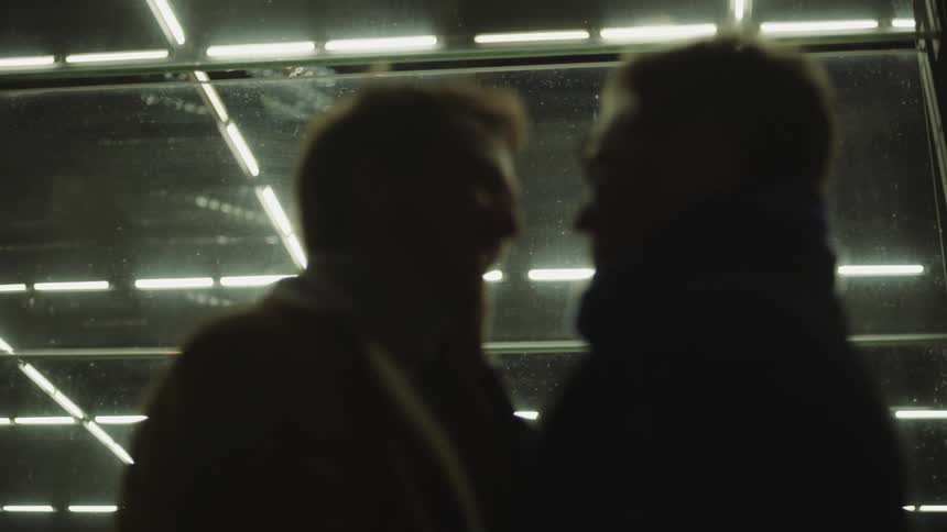 Two men kiss on a windy night