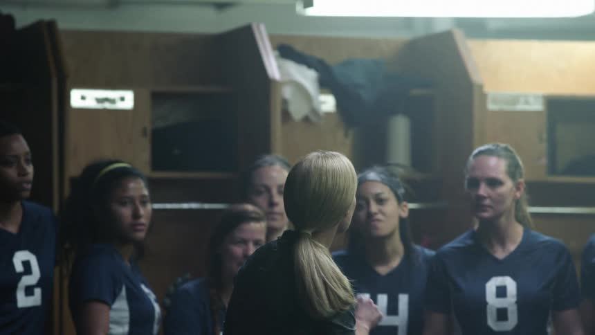 Coach talking to a female team on the locker room before the game