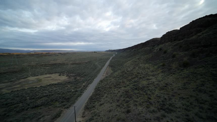 Pullback traverse over an empty and extremly rural road along a mountain ridge