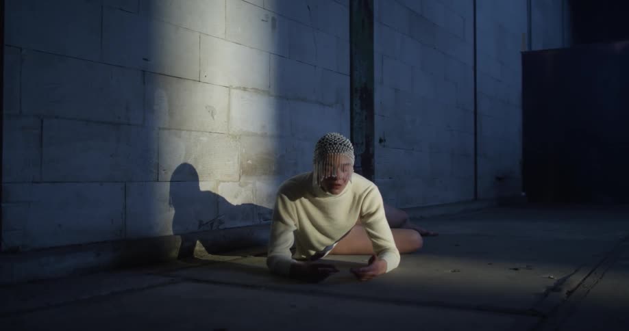 A woman lays on the floor in the dark room