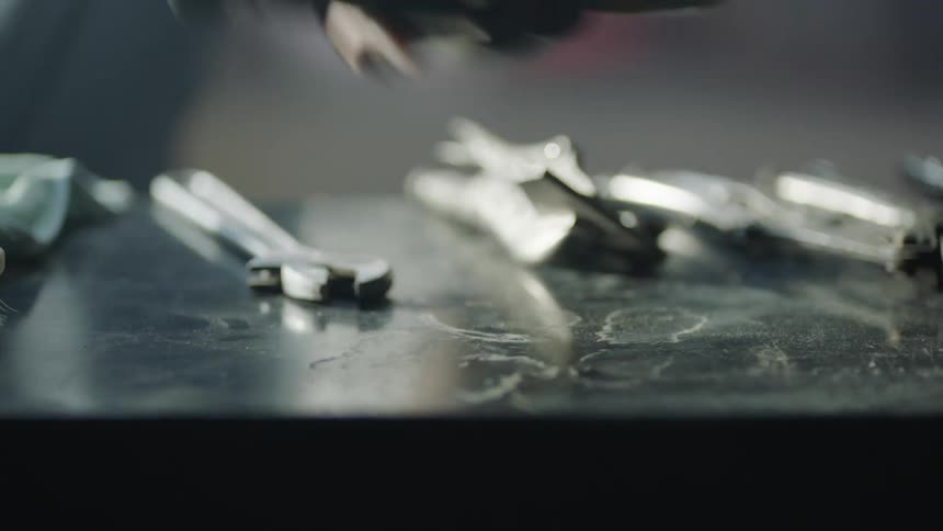 A worker grabbing a tool off of a table
