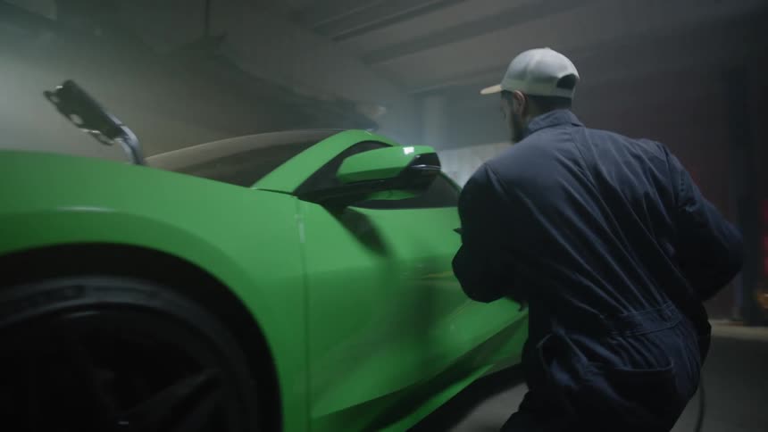 A person is working on a car in a car shop