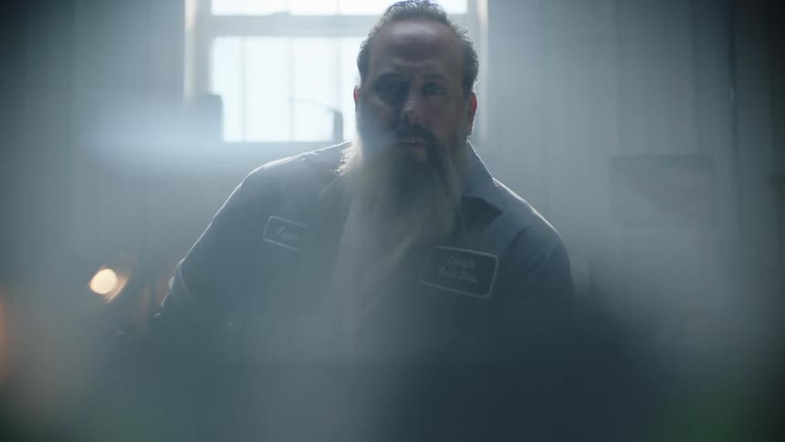 A man is sitting in the workshop in the dark