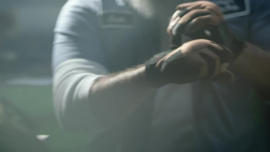 A male worker putting on gloves in a workshop