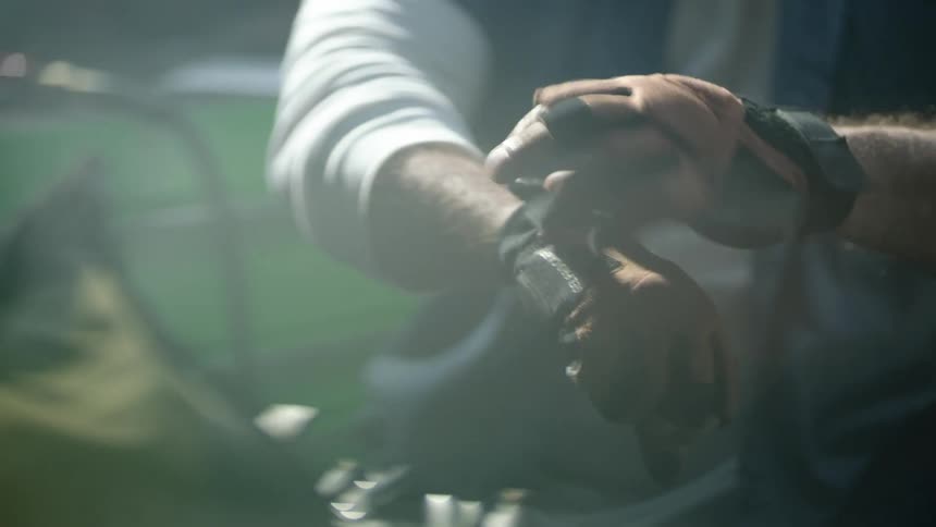 A man fastens his gloves in the yard