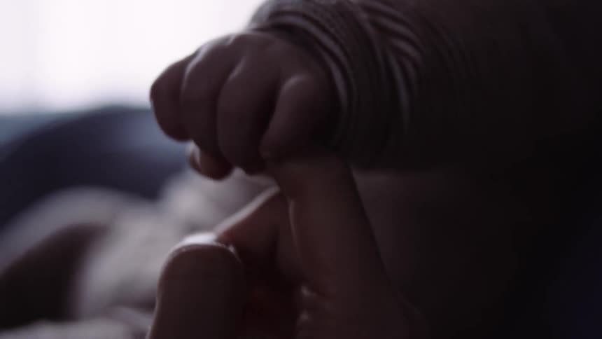 Mother plaing with her baby hands at home