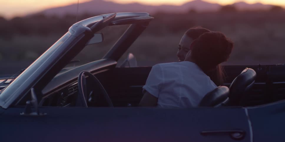 A man and woman are sitting in a car together
