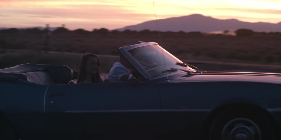 A car with two people make a turn on the highway