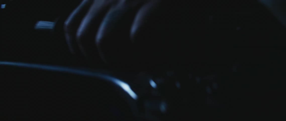 A bicyclist holds on tight to handlebars while riding at night