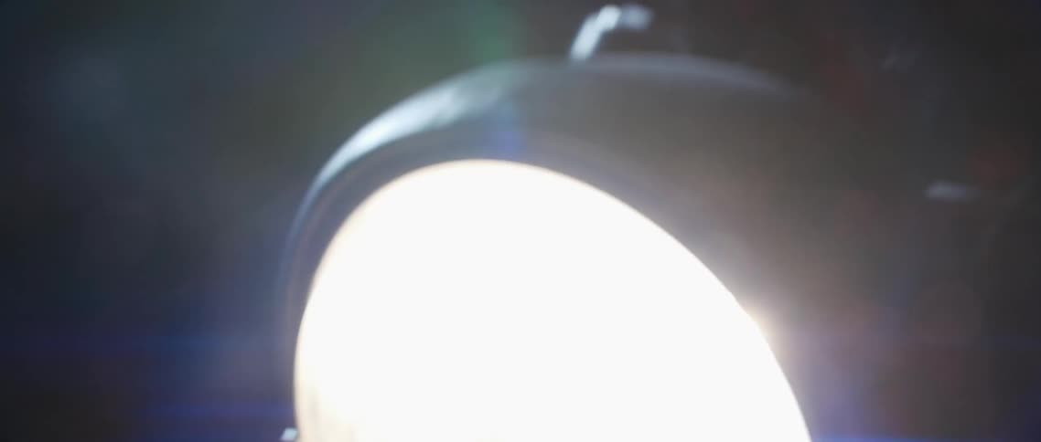 Flares and reflections of the moving headlight of a motorcycle at night
