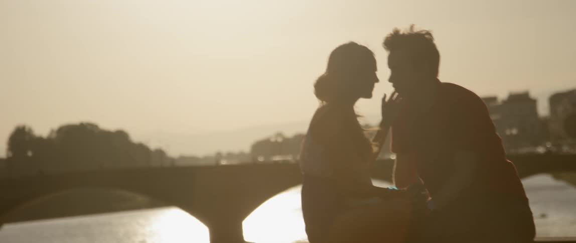 A man and woman talk in the sunlight