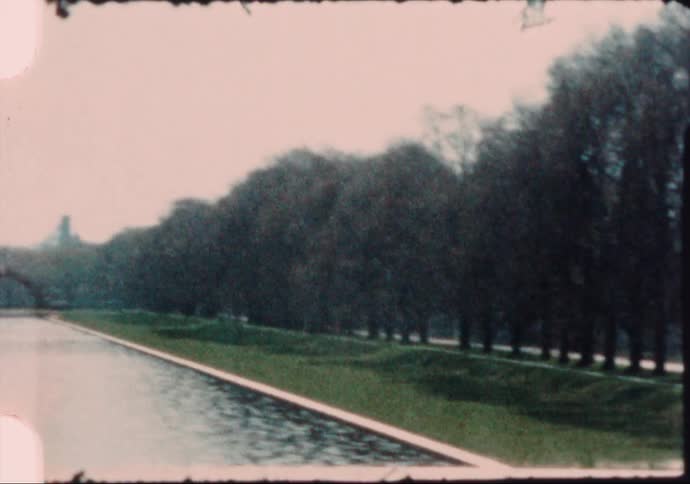 Car drives along avenue in next to pond leading to washington monument