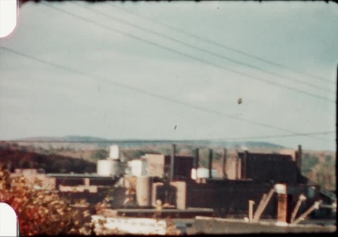 Smoke rises from factory near water tower