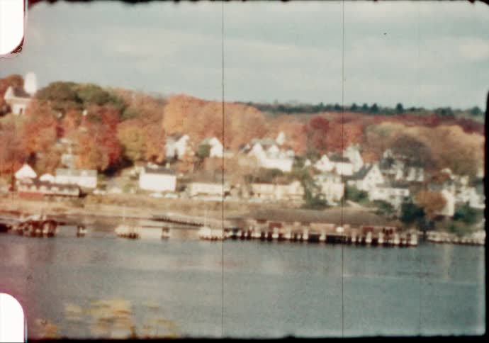 Large white homes sit along the lakefront as boats sit nearby