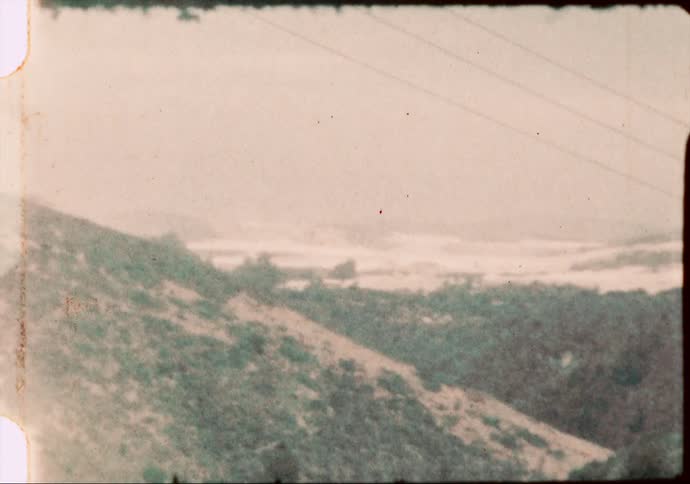 A lone road cuts through the rural western hill country of America in the 1960's