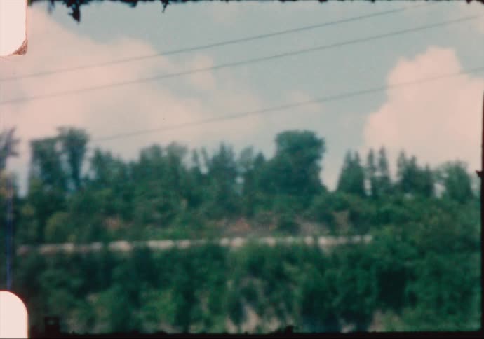 Vintage film of a waterfall flowing from the edge of a cliff in the woods